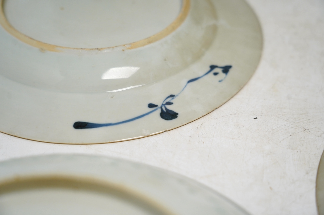Four Chinese blue and white export plates and a rice bowl, bowl 24.5cm diameter. Condition - poor to fair, some damage to the edges
